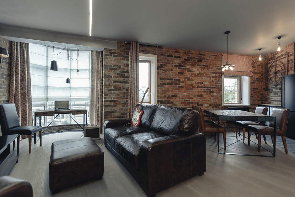 Foto di un soggiorno industriale di medie dimensioni e aperto con pareti marroni, parquet chiaro, TV a parete e pavimento beige