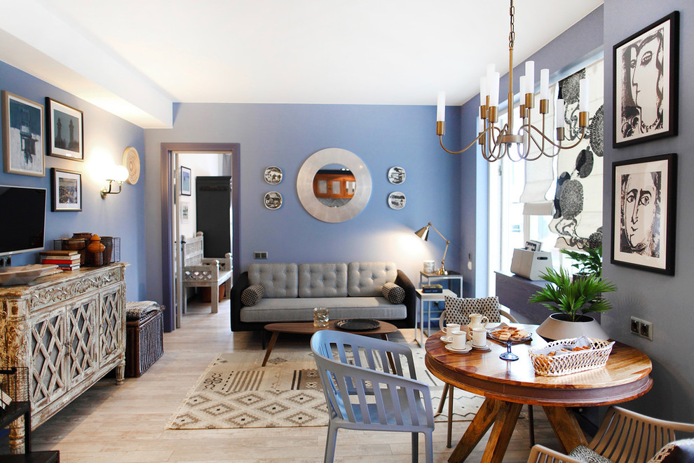 This is an example of a small eclectic open plan living room in Saint Petersburg with blue walls, light hardwood flooring, a freestanding tv and beige floors.