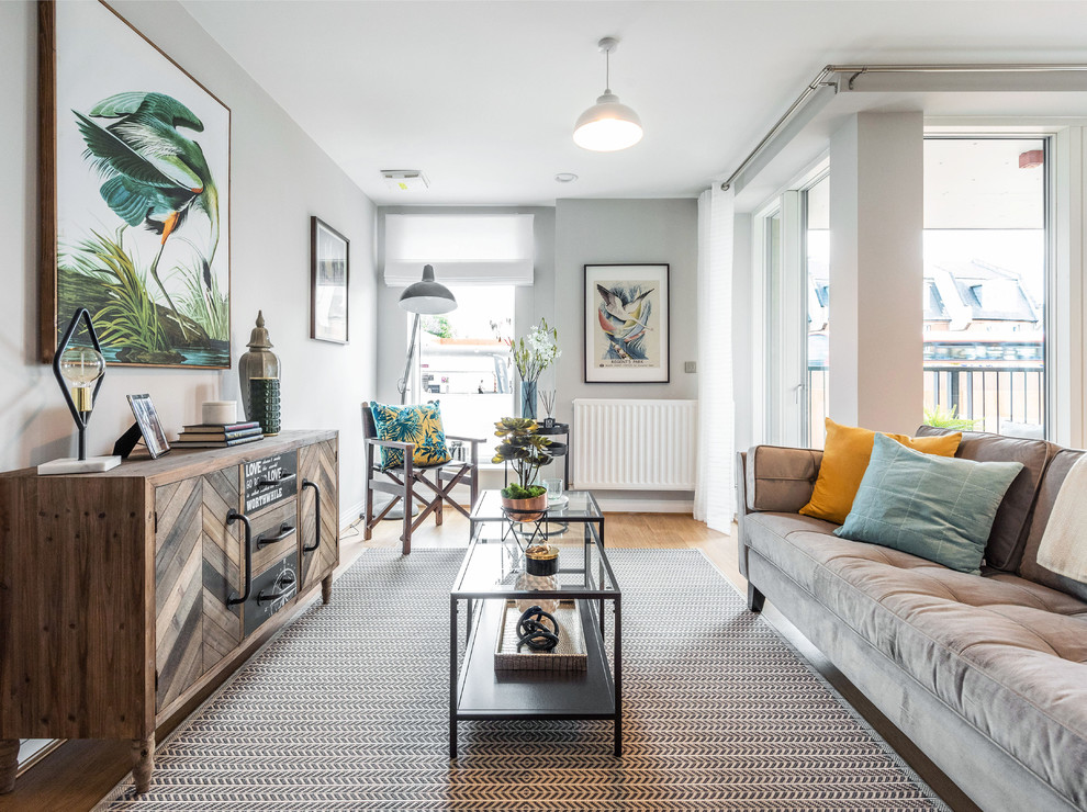 Kleines, Fernseherloses Modernes Wohnzimmer mit grauer Wandfarbe, hellem Holzboden und beigem Boden