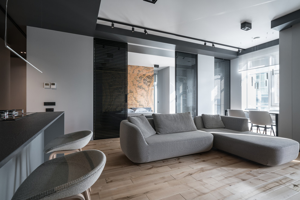 Стильный дизайн: открытая, объединенная гостиная комната в современном стиле с белыми стенами и бежевым полом - последний тренд