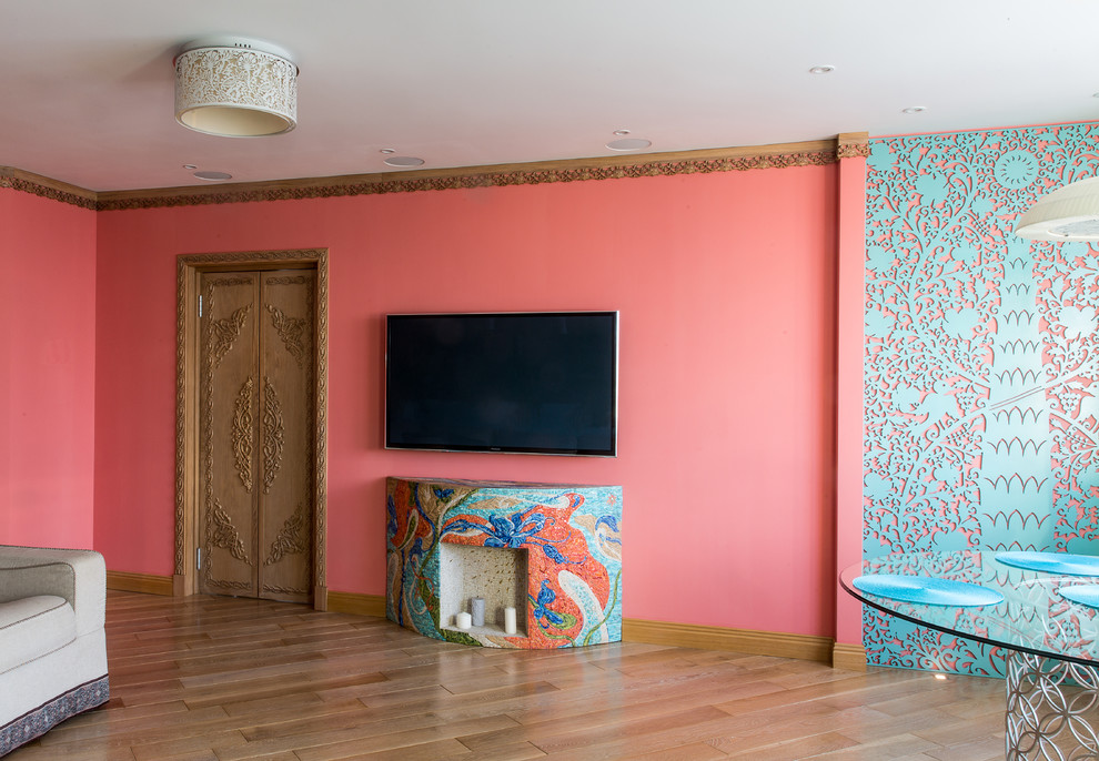 На фото: изолированная гостиная комната среднего размера в восточном стиле с розовыми стенами, паркетным полом среднего тона, горизонтальным камином, телевизором на стене и коричневым полом