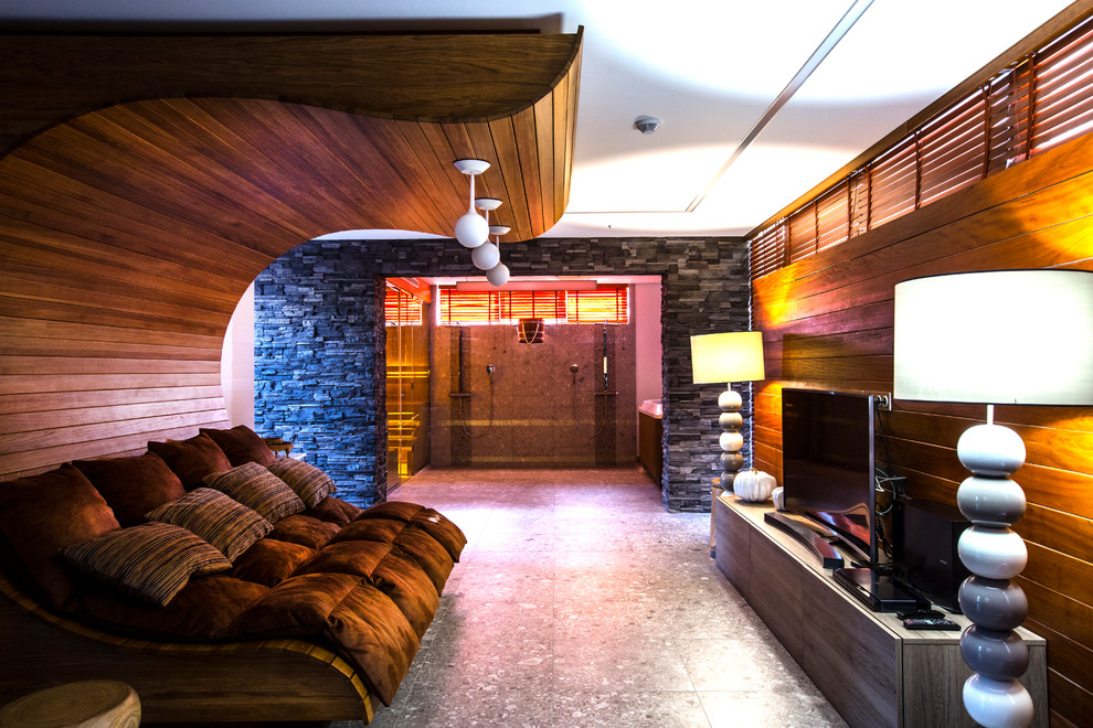 Inspiration för ett funkis allrum med öppen planlösning, med bruna väggar, en fristående TV och grått golv