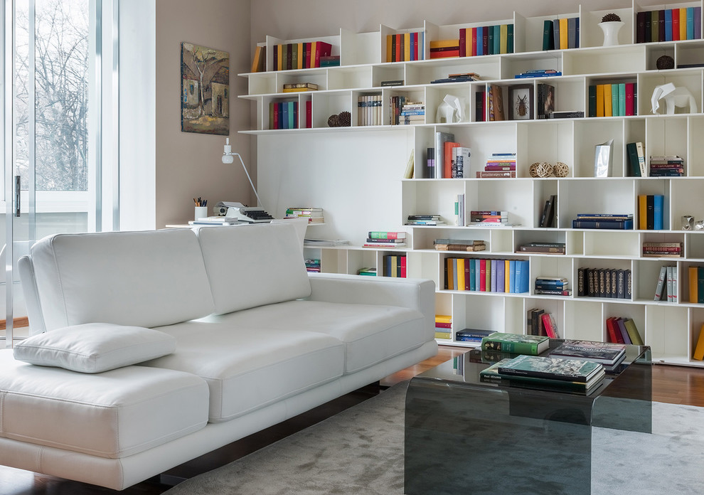 Ispirazione per un soggiorno design con pareti beige, pavimento in legno massello medio, pavimento marrone e libreria