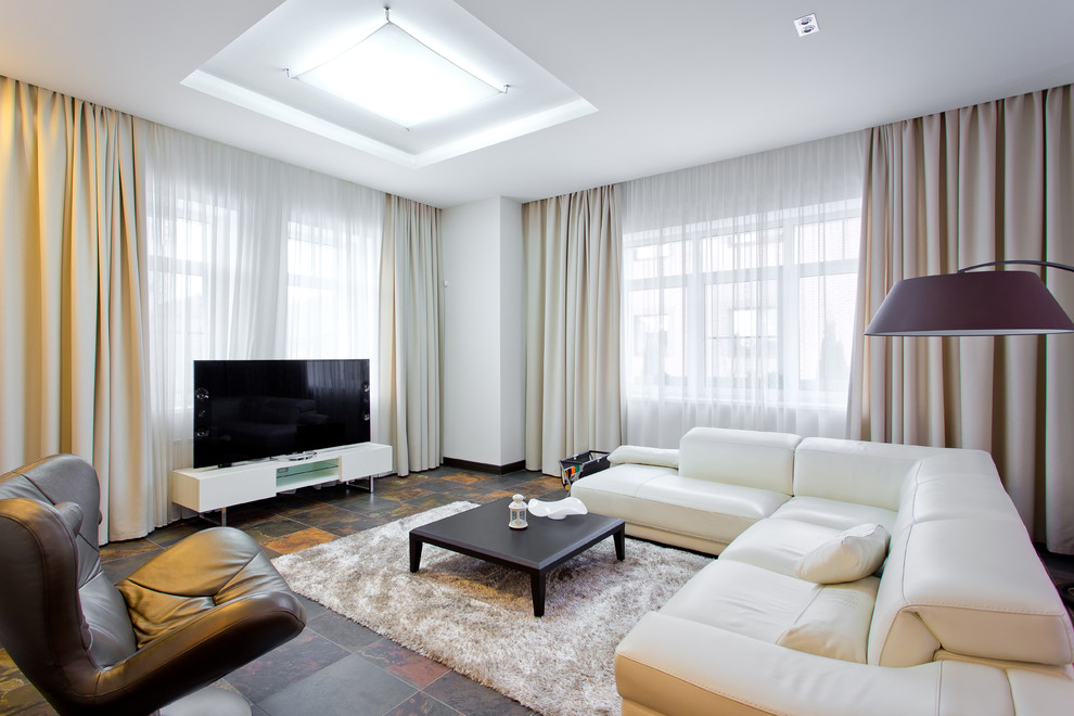 Imagen de sala de estar abierta contemporánea con paredes blancas y televisor independiente