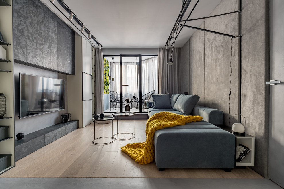 Foto di un piccolo soggiorno minimal con pareti grigie, parquet chiaro, TV a parete e pavimento beige