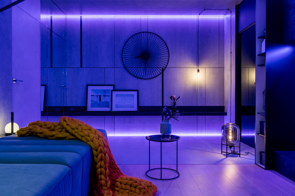 На фото: маленькая гостиная комната в современном стиле с серыми стенами, светлым паркетным полом, бежевым полом и телевизором на стене для на участке и в саду