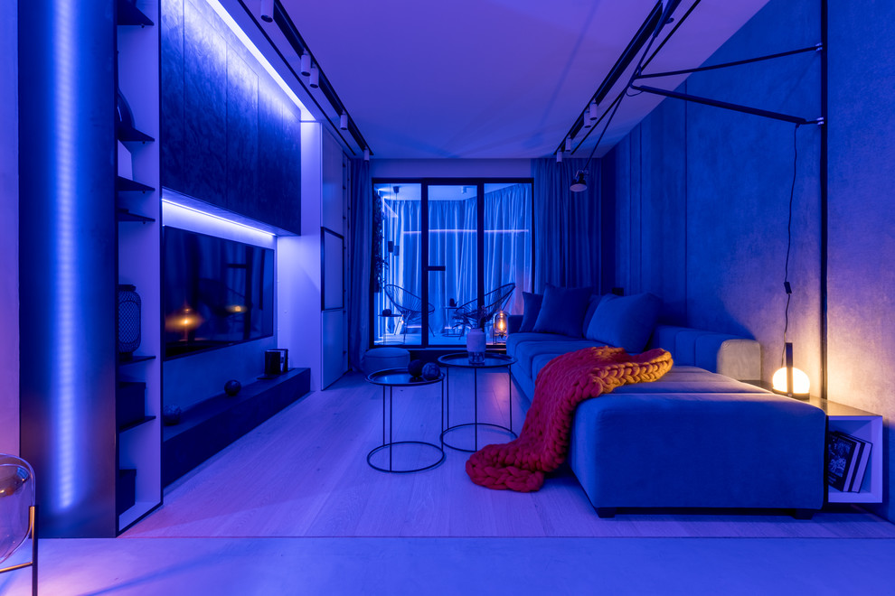 Esempio di un piccolo soggiorno contemporaneo con pareti grigie, parquet chiaro, pavimento beige e TV a parete