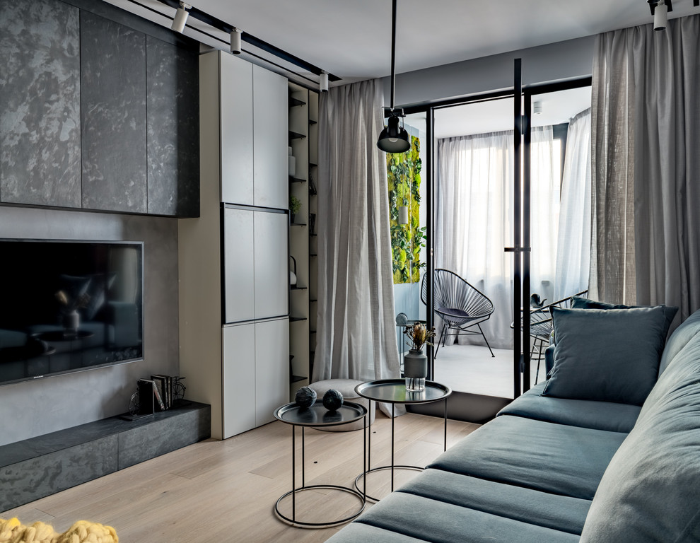 На фото: маленькая объединенная гостиная комната в современном стиле с серыми стенами, светлым паркетным полом, телевизором на стене и бежевым полом для на участке и в саду с