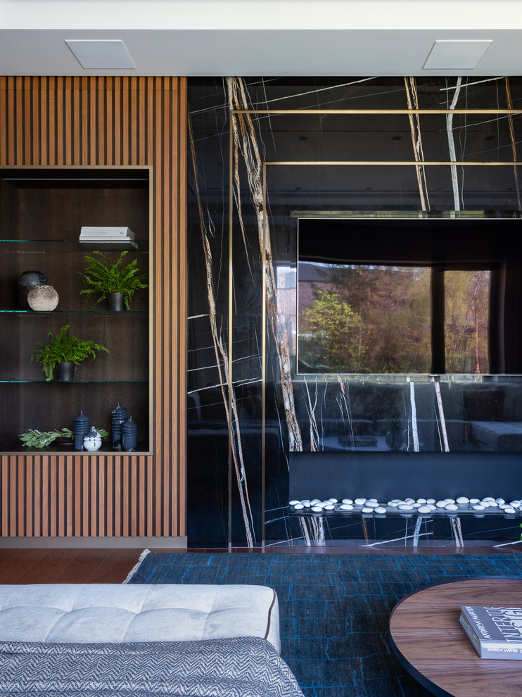 Идея дизайна: гостиная комната в современном стиле с черными стенами, телевизором на стене и коричневым полом