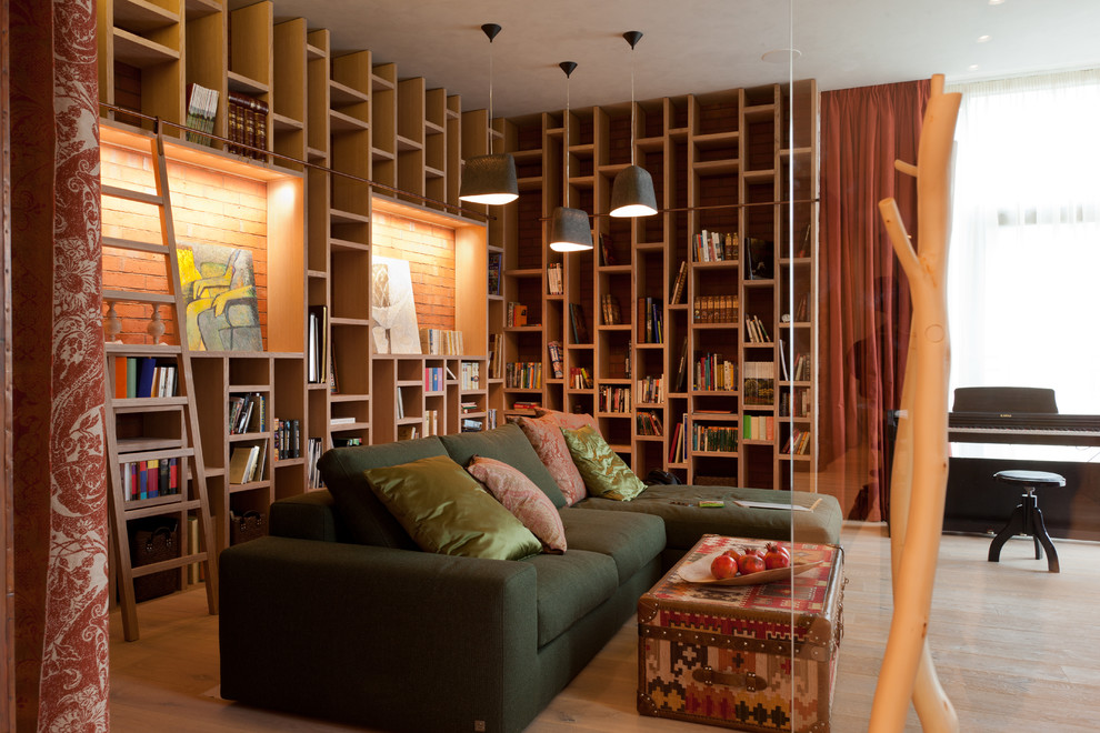 Cette image montre une salle de séjour design fermée avec une bibliothèque ou un coin lecture et parquet clair.