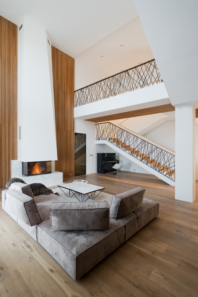 Diseño de salón escandinavo con paredes blancas, suelo de madera en tonos medios y suelo marrón
