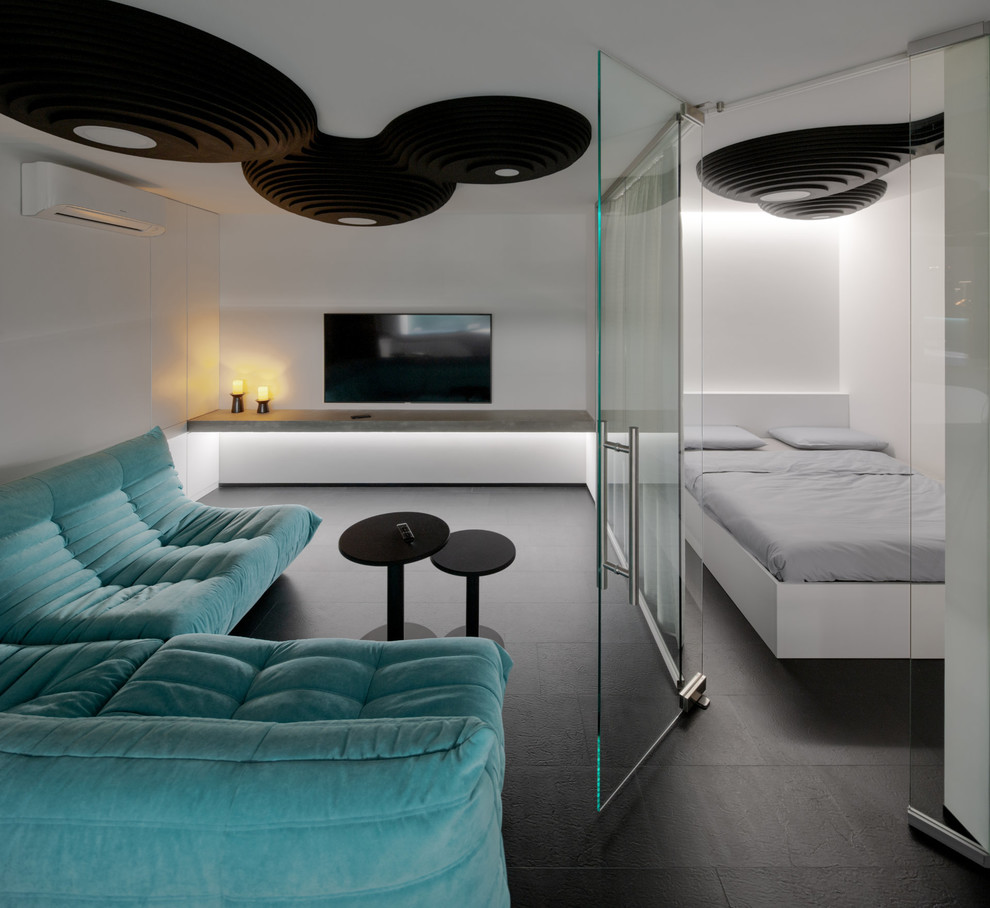 Immagine di un soggiorno contemporaneo di medie dimensioni con pareti bianche, pavimento in vinile, TV a parete e pavimento nero