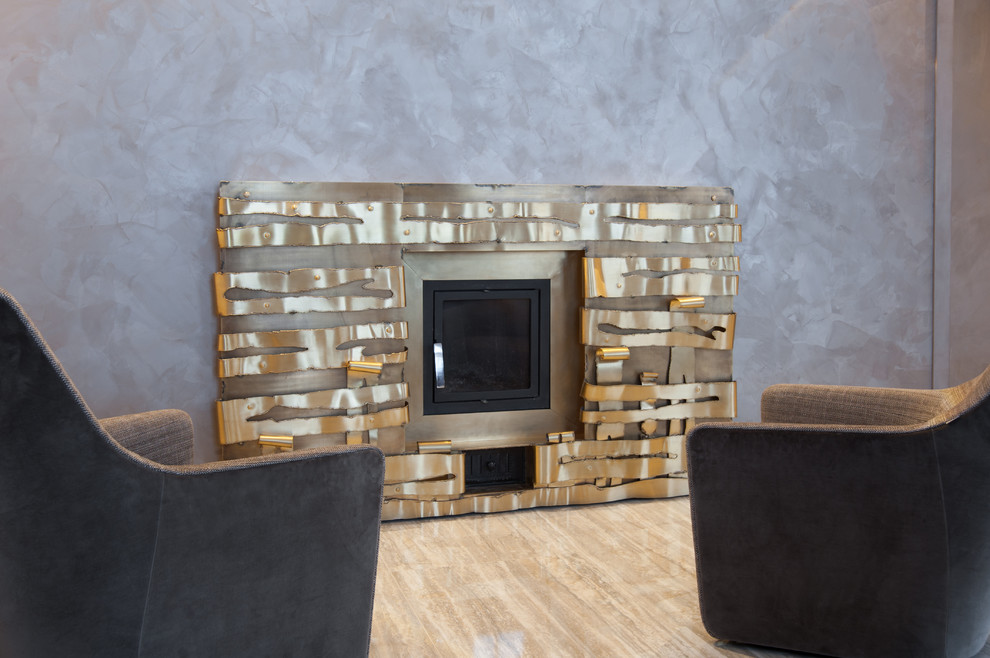 Идея дизайна: изолированная гостиная комната среднего размера в современном стиле с бежевыми стенами, полом из керамогранита, стандартным камином, фасадом камина из металла, отдельно стоящим телевизором и бежевым полом