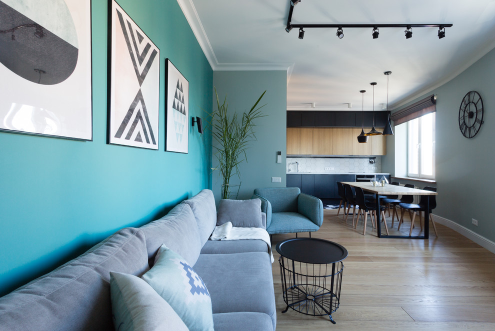 Идея дизайна: открытая гостиная комната среднего размера в современном стиле с синими стенами, паркетным полом среднего тона, телевизором на стене и бежевым полом