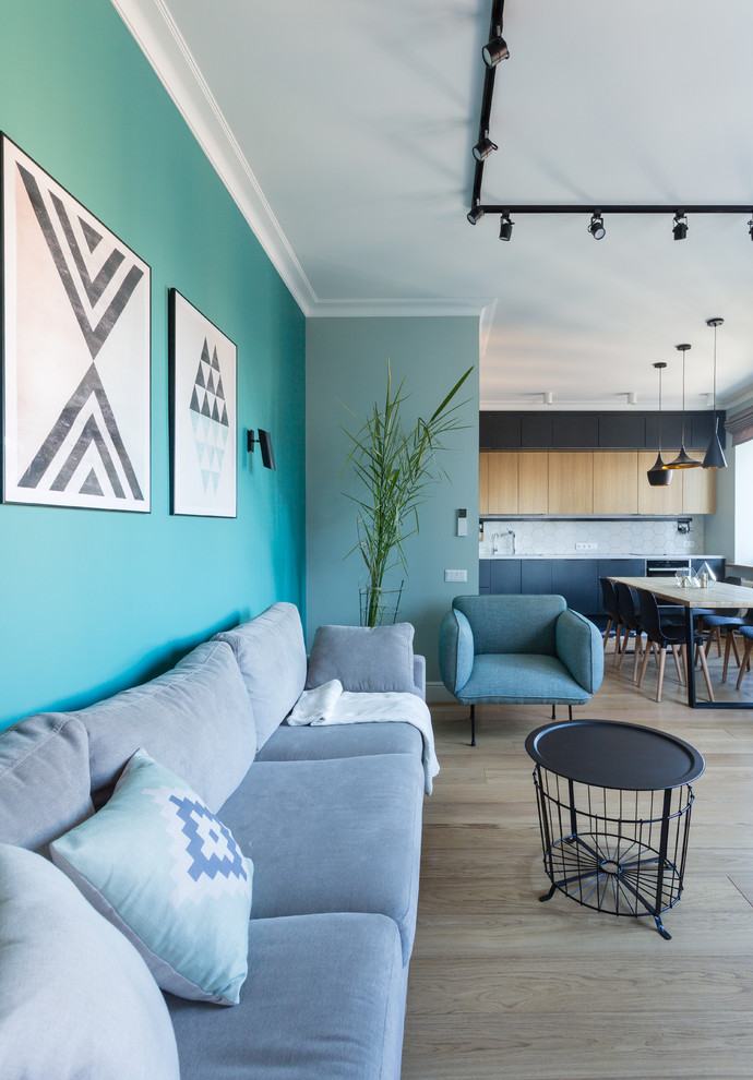 Réalisation d'un salon design de taille moyenne et ouvert avec un mur bleu, un sol en bois brun, un téléviseur fixé au mur et un sol beige.