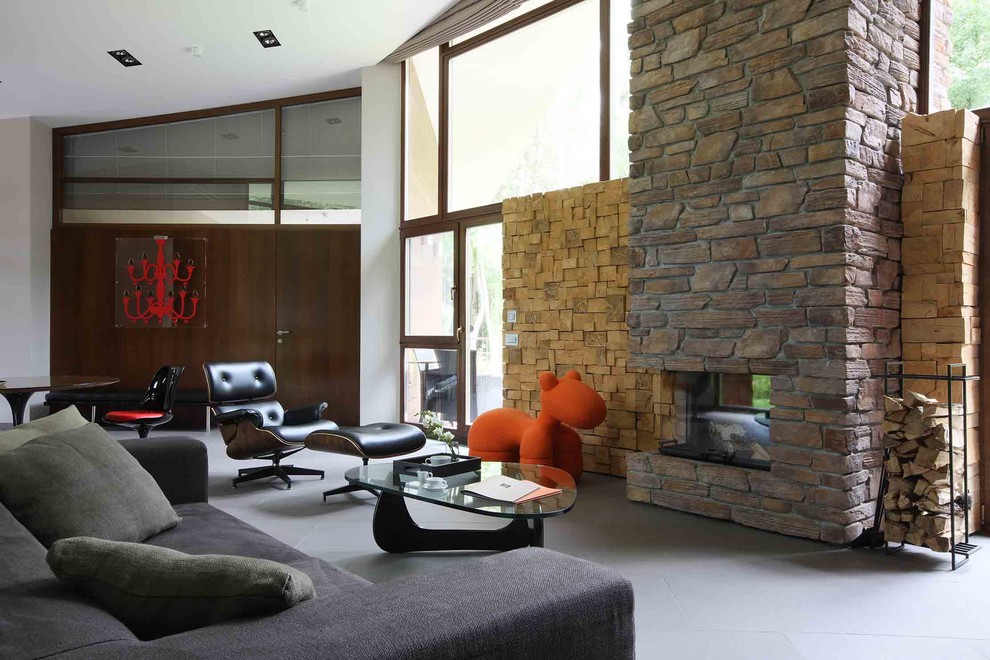 Foto de salón minimalista de tamaño medio con paredes marrones, suelo de pizarra, chimenea lineal, marco de chimenea de piedra y televisor retractable