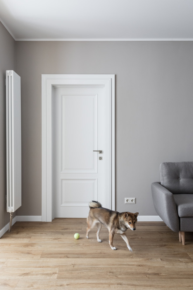 На фото: гостиная комната среднего размера в классическом стиле с серыми стенами, полом из ламината и коричневым полом с