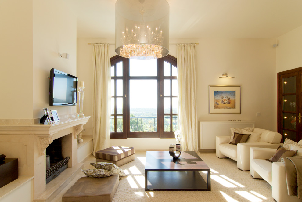 Großes, Offenes Country Wohnzimmer mit beiger Wandfarbe, Marmorboden, Kamin, Kaminumrandung aus Stein und TV-Wand in Palma de Mallorca