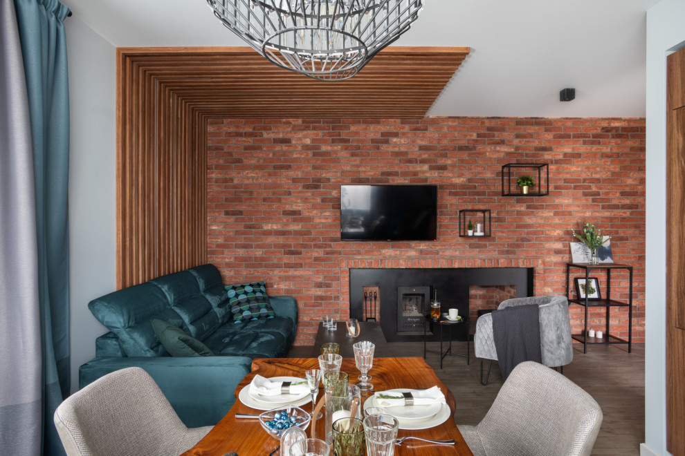 На фото: открытая, объединенная гостиная комната среднего размера в современном стиле с полом из керамогранита, горизонтальным камином, фасадом камина из металла, телевизором на стене, серым полом, белыми стенами и синим диваном