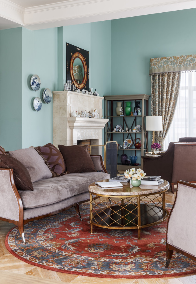 Esempio di un soggiorno classico aperto con sala formale, pareti blu, parquet chiaro, camino classico e cornice del camino piastrellata