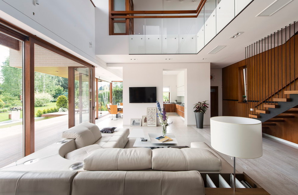 Esempio di un soggiorno design aperto con pareti bianche, parquet chiaro, nessun camino, TV a parete e pavimento beige