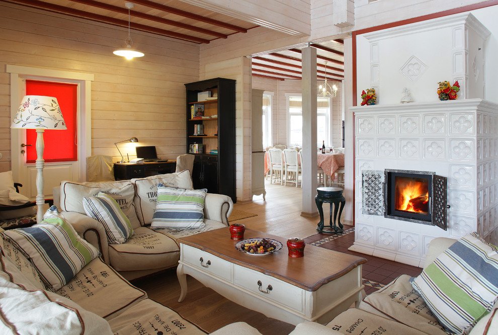 Cette photo montre un salon nature ouvert avec une salle de réception, un mur beige, un sol en bois brun, un poêle à bois et un manteau de cheminée en carrelage.