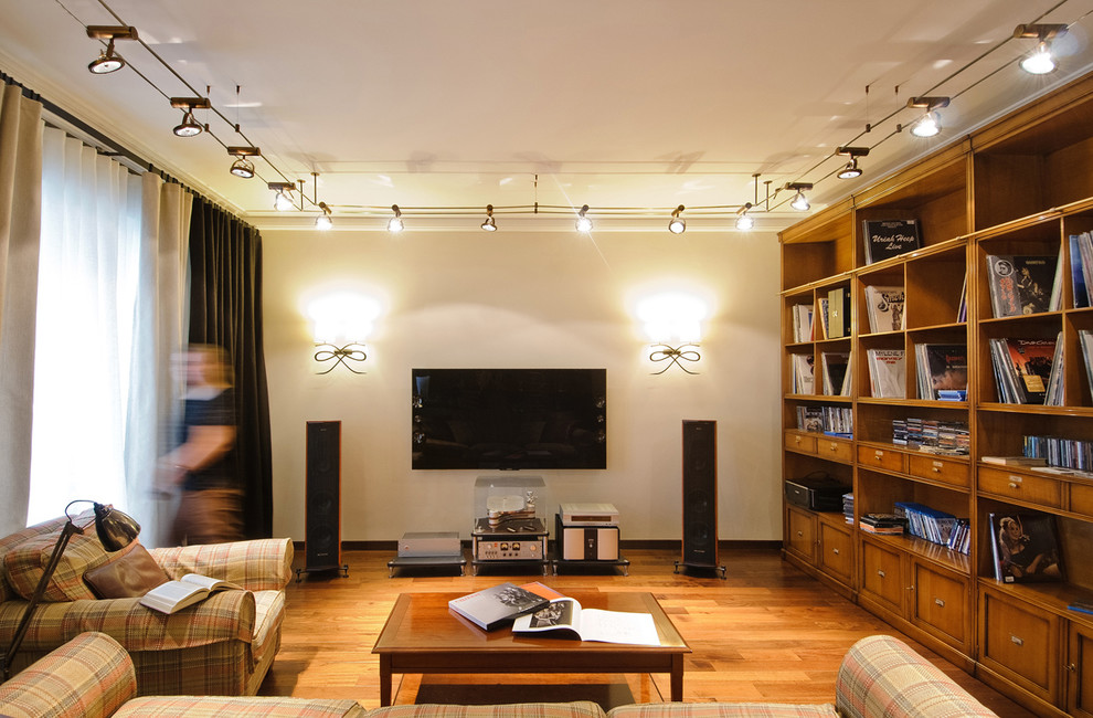 Idee per un soggiorno contemporaneo chiuso con libreria, pareti bianche, pavimento in legno massello medio e TV a parete