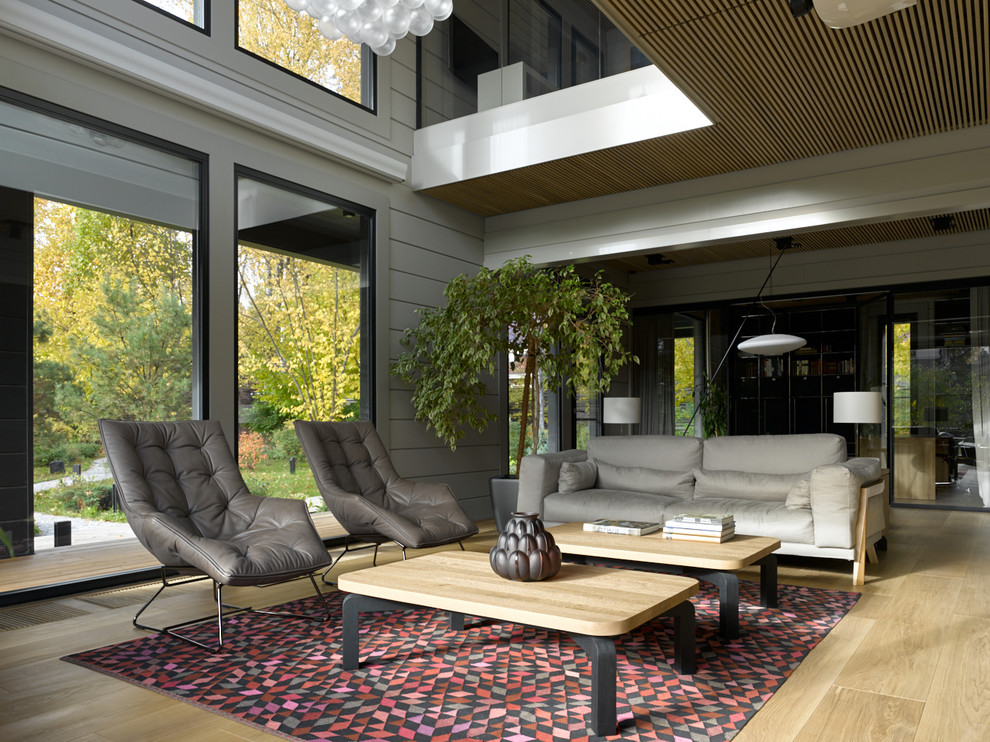 Ejemplo de salón contemporáneo con paredes grises, suelo de madera clara y suelo beige