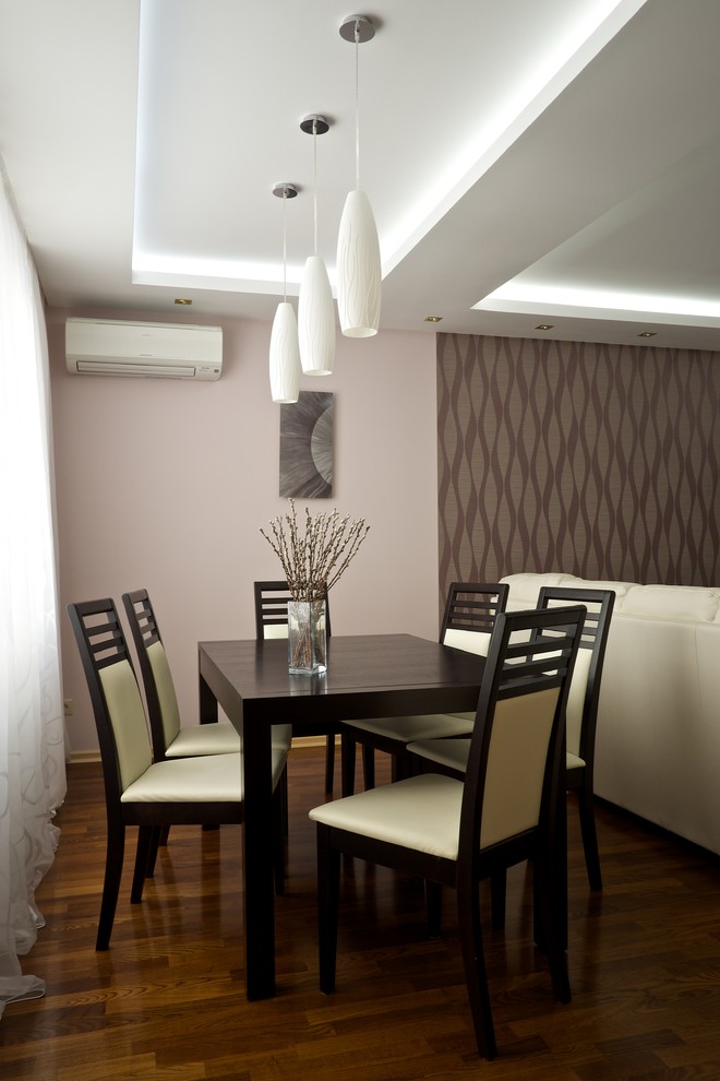 Пример оригинального дизайна: столовая среднего размера в современном стиле с розовыми стенами, темным паркетным полом, подвесным камином, фасадом камина из штукатурки и коричневым полом
