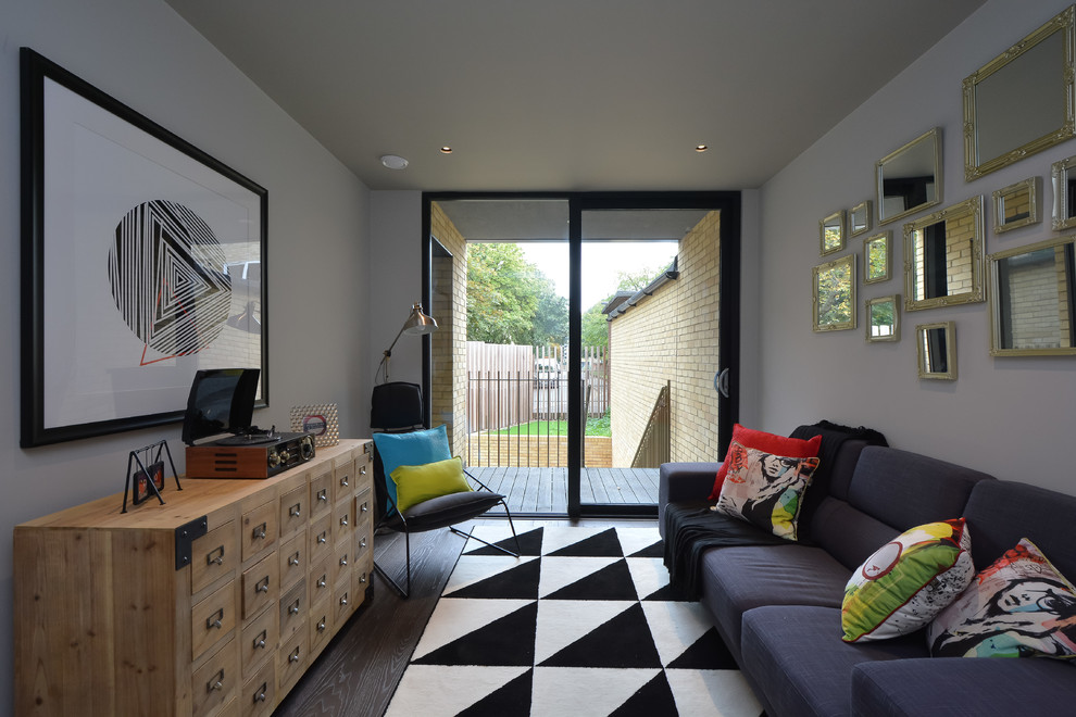 Idée de décoration pour un salon design avec un mur gris et un sol marron.