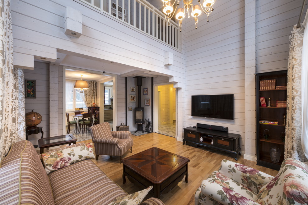 Immagine di un piccolo soggiorno classico aperto con sala formale, stufa a legna, cornice del camino in metallo e TV a parete