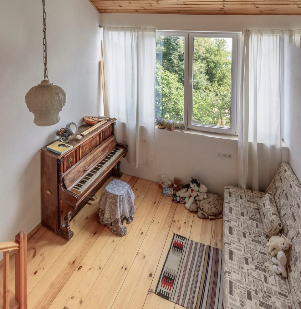 Foto på ett litet lantligt allrum med öppen planlösning, med ett musikrum, vita väggar, målat trägolv och beiget golv