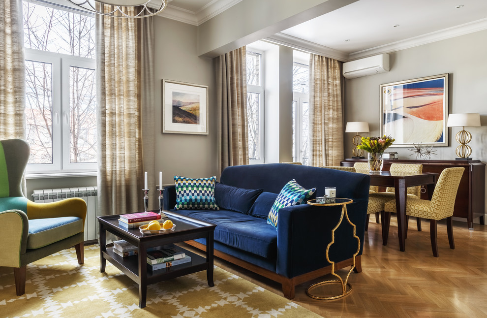 Foto di un soggiorno classico aperto e di medie dimensioni con sala formale, pareti grigie, pavimento in legno massello medio, pavimento marrone e TV a parete