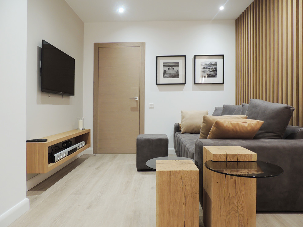 Bild på ett mellanstort funkis separat vardagsrum, med en hemmabar, vita väggar, laminatgolv, en väggmonterad TV och beiget golv