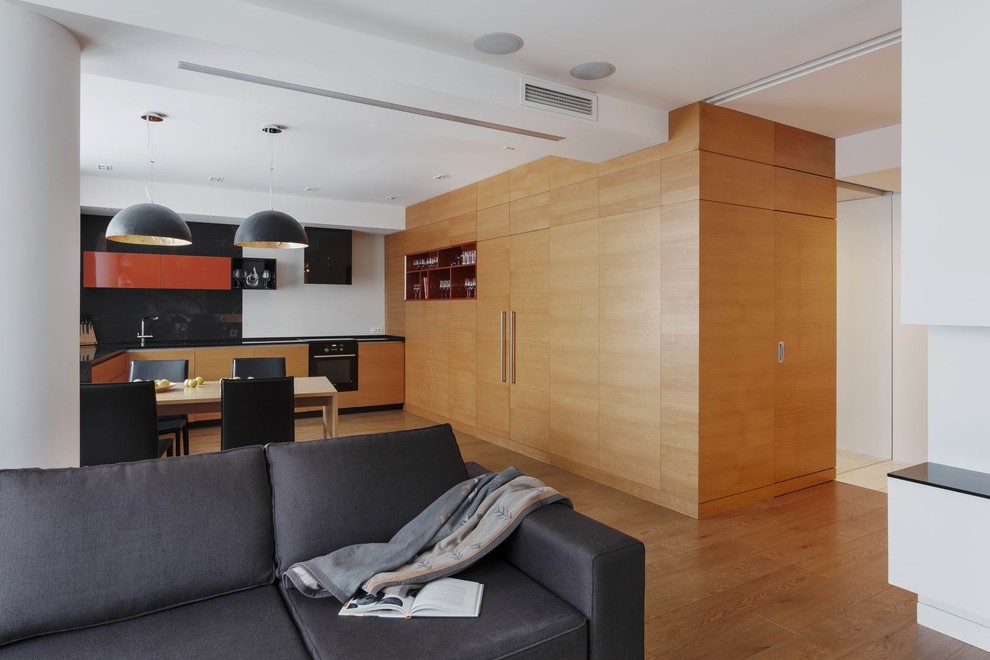 Идея дизайна: открытая, объединенная гостиная комната среднего размера в современном стиле с белыми стенами, полом из ламината, телевизором на стене и бежевым полом без камина