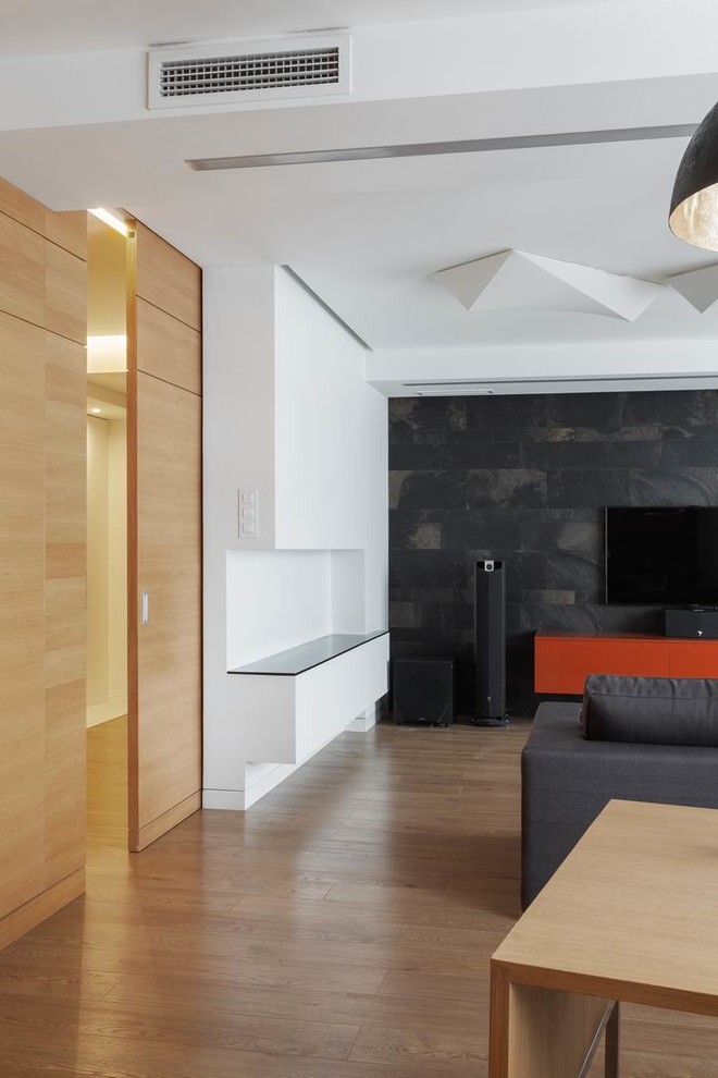 Стильный дизайн: открытая гостиная комната среднего размера в современном стиле с белыми стенами, полом из ламината, телевизором на стене и бежевым полом без камина - последний тренд