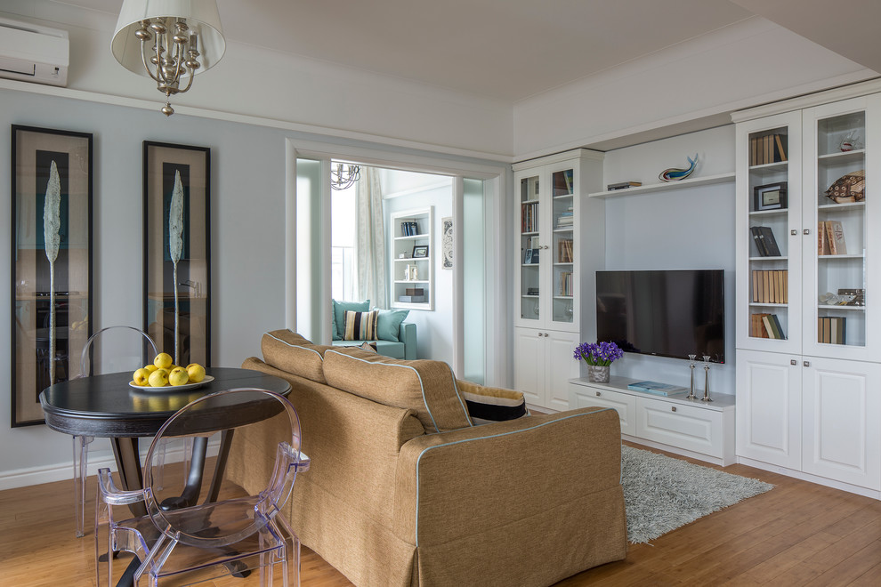 Immagine di un soggiorno classico con sala formale, pareti blu, pavimento in legno massello medio e TV a parete