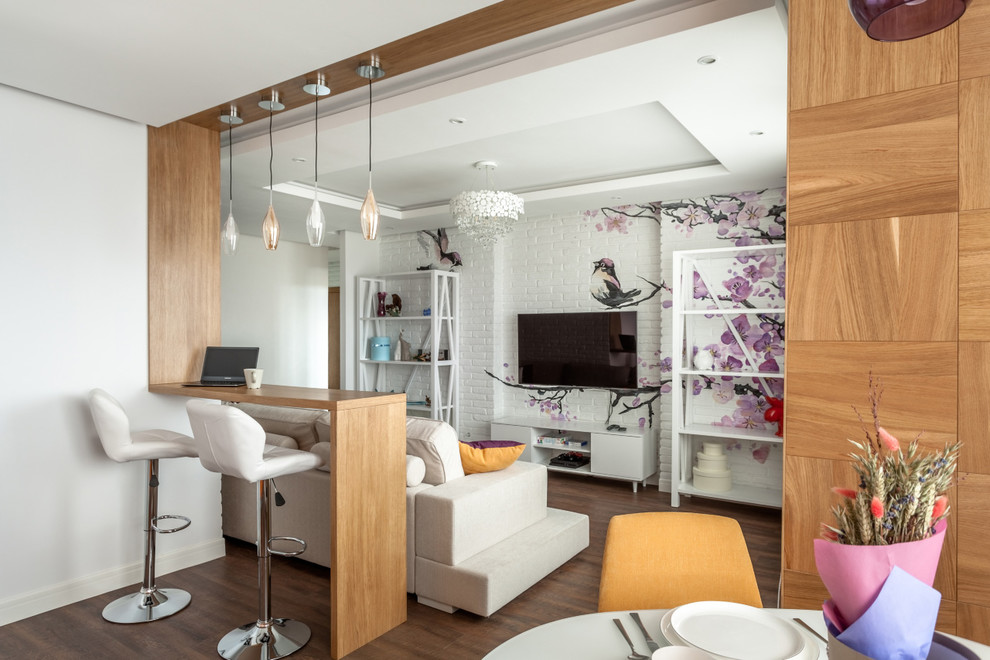 Cette image montre un petit salon bohème ouvert avec un sol en vinyl, un sol marron, un mur blanc et un téléviseur fixé au mur.
