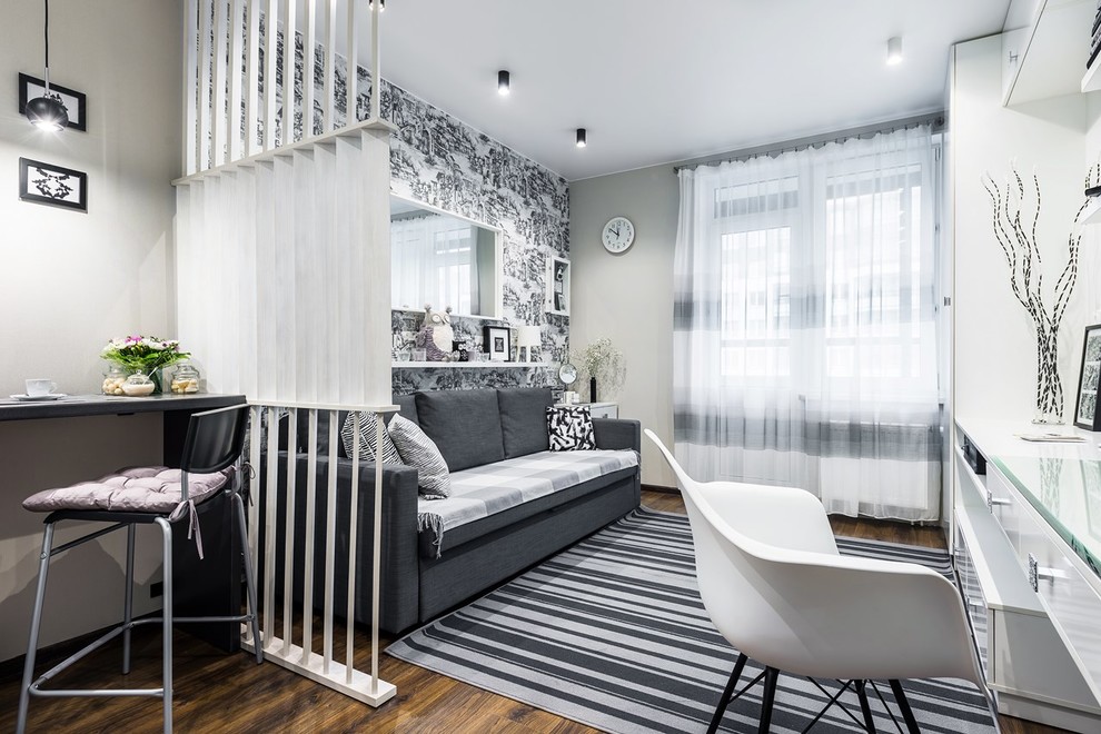 Foto de sala de estar abierta contemporánea pequeña con paredes grises, suelo laminado, televisor independiente y suelo marrón