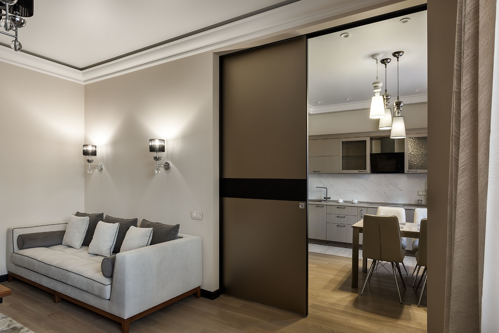 На фото: большая изолированная гостиная комната в стиле неоклассика (современная классика) с бежевыми стенами, паркетным полом среднего тона, телевизором на стене и бежевым полом
