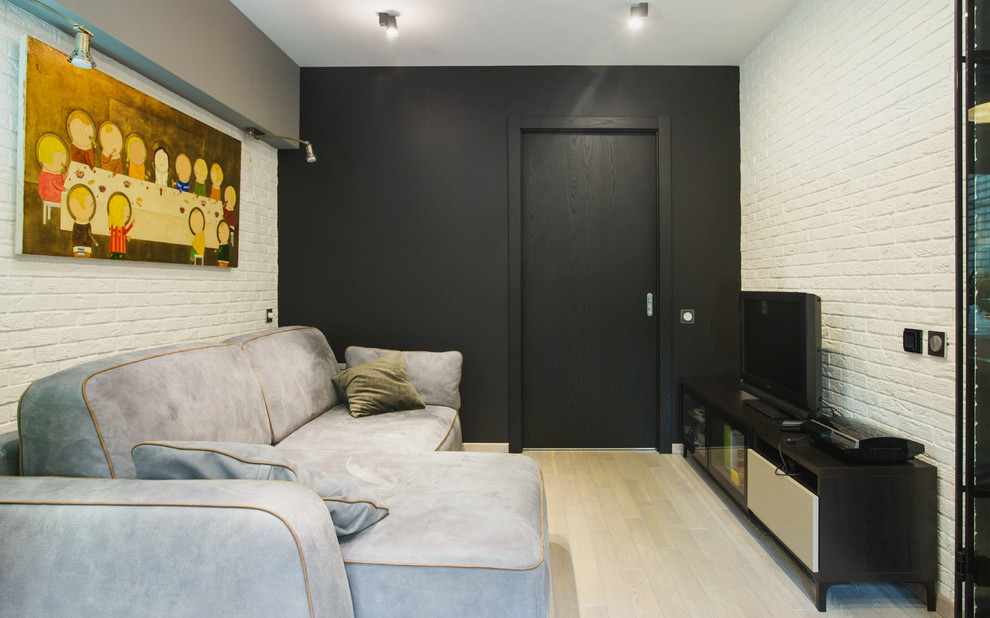 This is an example of a medium sized industrial mezzanine living room in Moscow with white walls, laminate floors, no fireplace, a freestanding tv and beige floors.