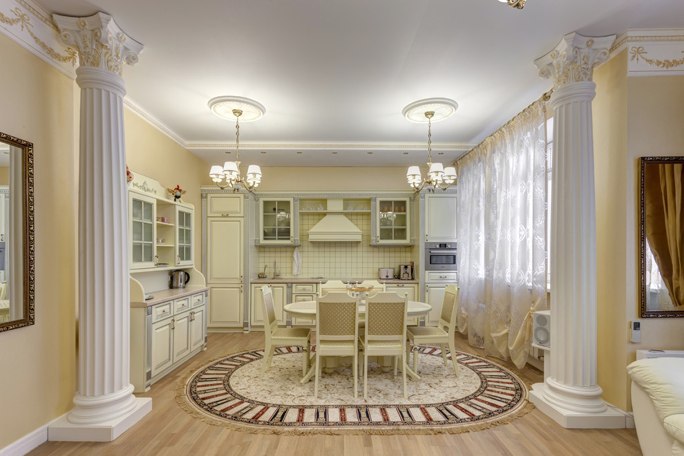 Стильный дизайн: объединенная гостиная комната в классическом стиле с желтыми стенами, полом из ламината и бежевым полом без камина - последний тренд