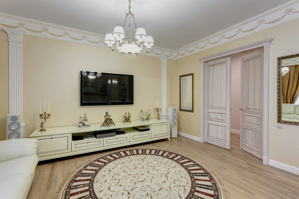Inspiration för mellanstora klassiska vardagsrum, med gula väggar, laminatgolv, en väggmonterad TV och beiget golv