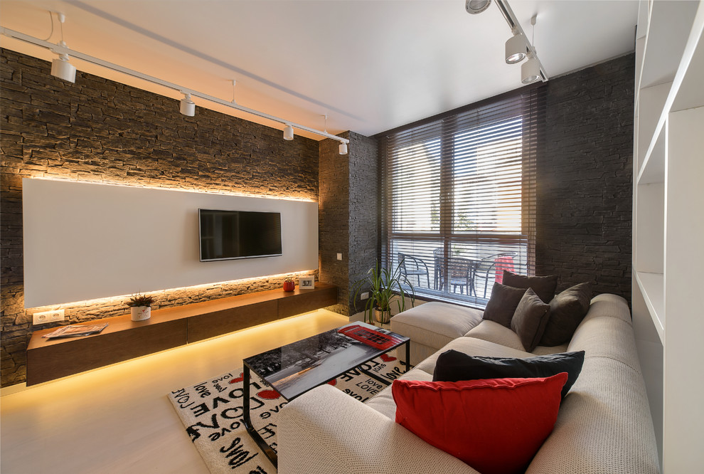 Источник вдохновения для домашнего уюта: парадная, открытая гостиная комната в современном стиле с черными стенами и телевизором на стене