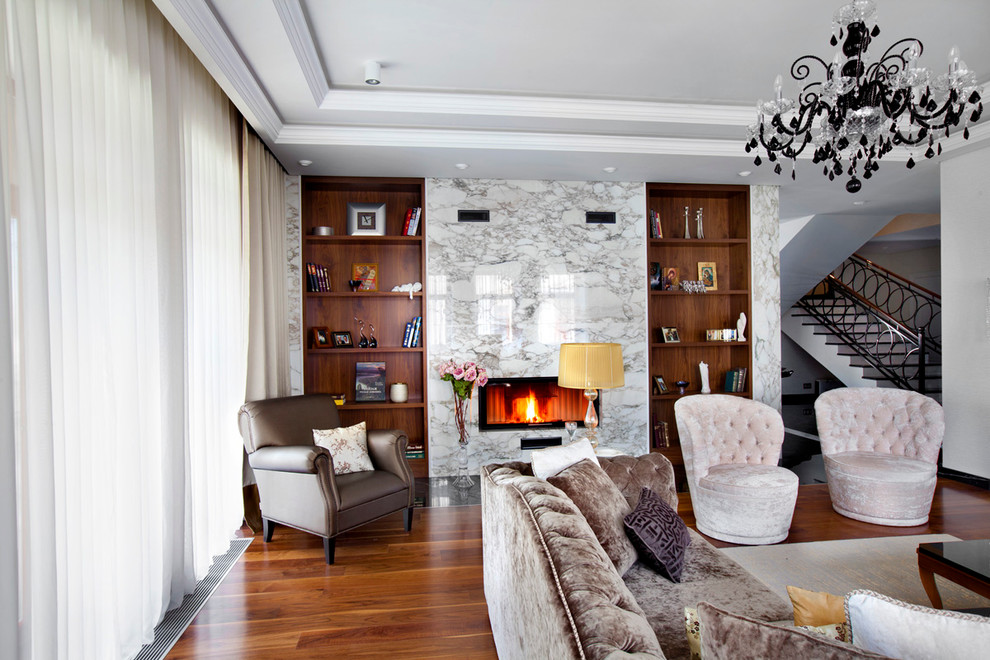 Immagine di un soggiorno design con pavimento in legno massello medio, camino classico e cornice del camino in pietra