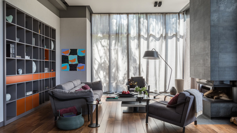 Свежая идея для дизайна: гостиная комната в современном стиле с серыми стенами, паркетным полом среднего тона, стандартным камином и коричневым полом - отличное фото интерьера