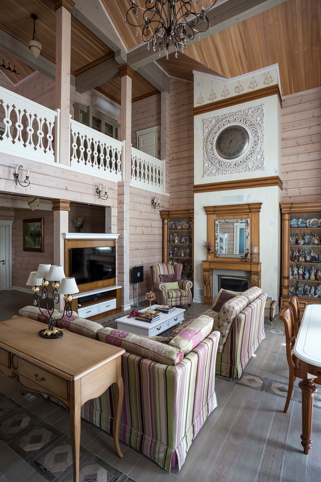 Geräumiges Stilmix Wohnzimmer mit beiger Wandfarbe, braunem Holzboden, Kamin und TV-Wand in Sonstige