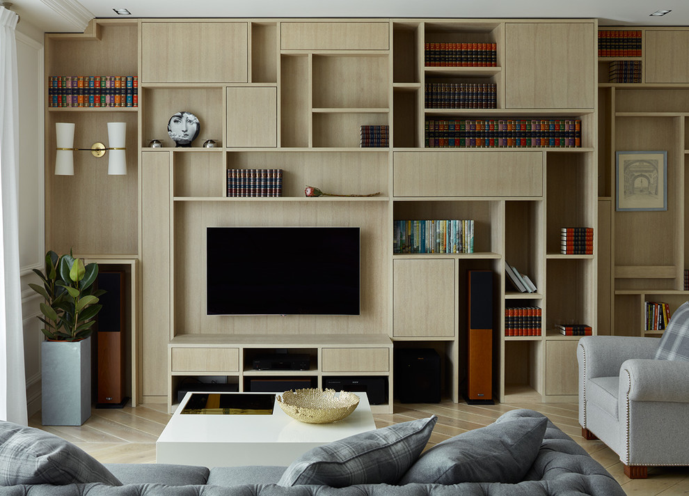 Imagen de biblioteca en casa abierta actual con paredes blancas, suelo de madera clara, televisor colgado en la pared y suelo beige