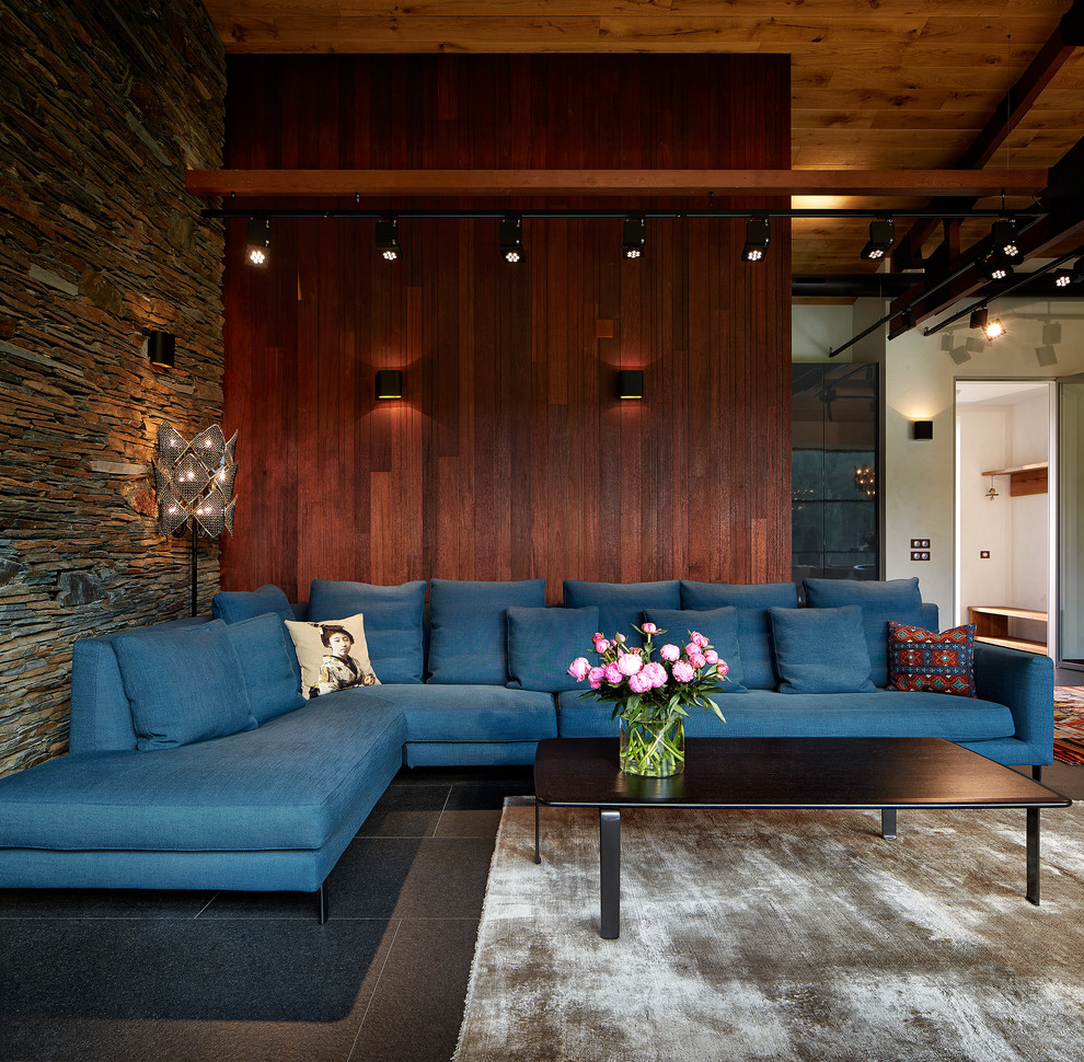 Идея дизайна: открытая гостиная комната среднего размера в современном стиле с коричневыми стенами, полом из керамогранита и синим диваном