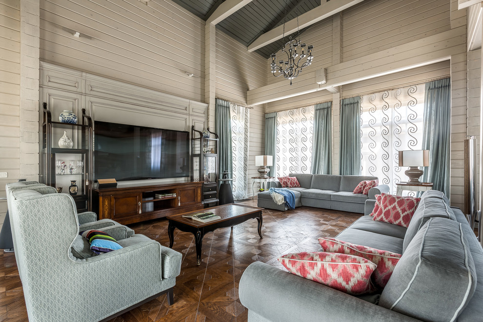 Diseño de salón para visitas abierto clásico renovado grande con suelo de madera en tonos medios, televisor colgado en la pared, suelo marrón y paredes blancas